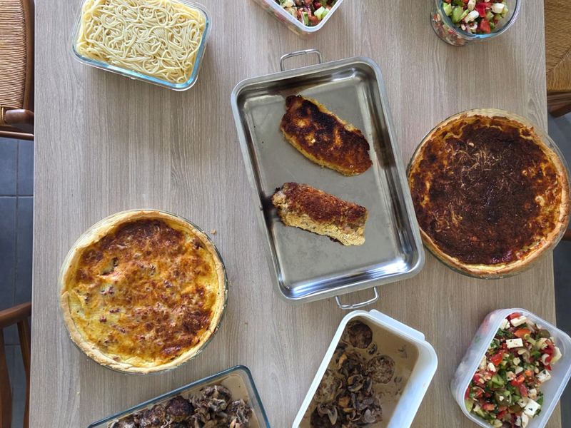 Vue du dessus de boîtes en verre remplies de quiches, salades, pâtes et légumes