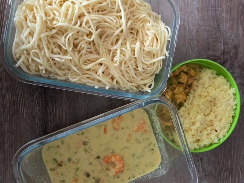Boîtes en verre contenant des pâtes, du riz et un curry de crevettes